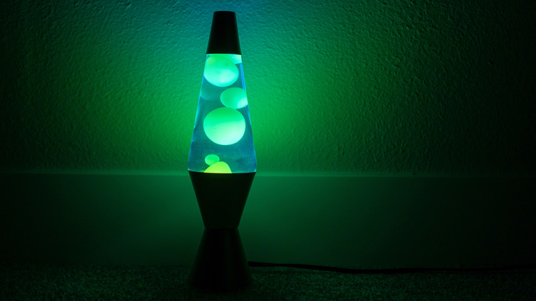 A blue-green lava lamp illuminating a dark room.
