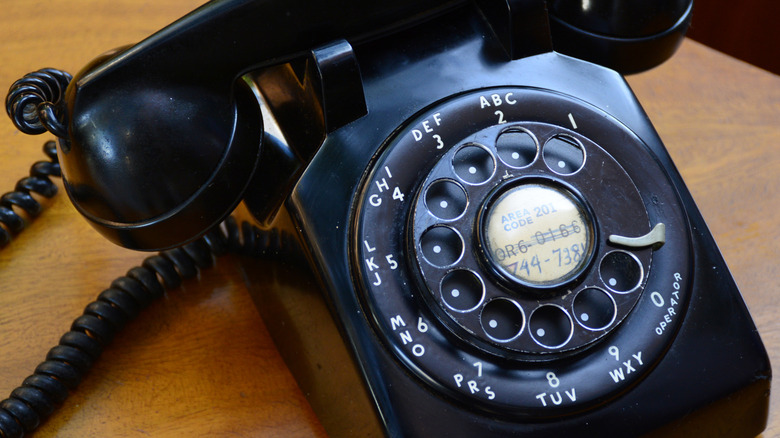 A closeup of a black vintage rotary phone