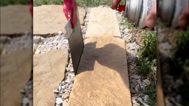 Person spray painting landscape rocks