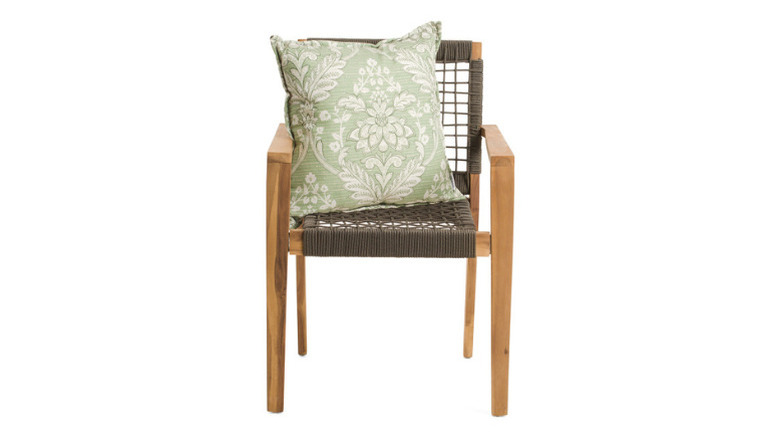One of Curated Kravet's Eirene Damask Pillows on a wooden chair, on a white background