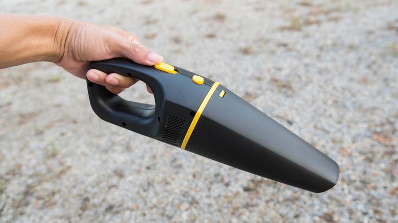 Hand holding small car vacuum