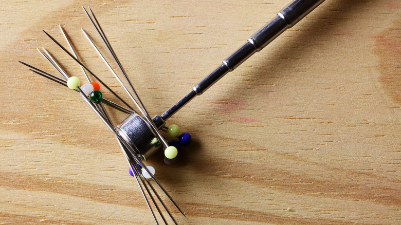 Pins stuck to a telescoping magnetic tool