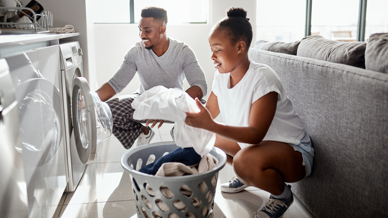 Shot of a happy young couple doing laundry together at home