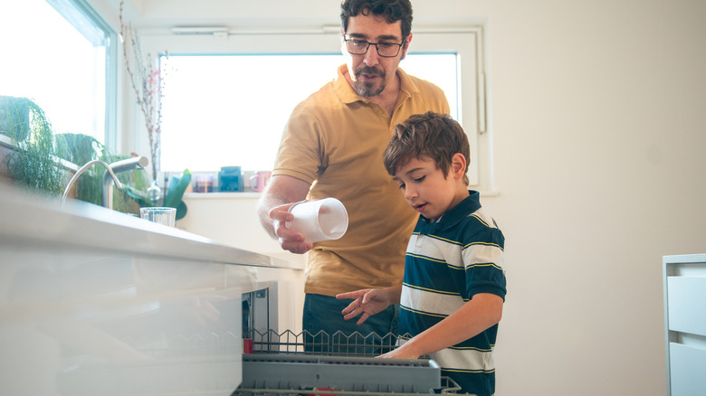 Father and son loading the dishwasher