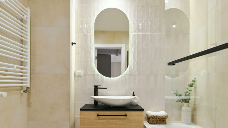 Modern and simple bathroom with oval mirrored medicine cabinet