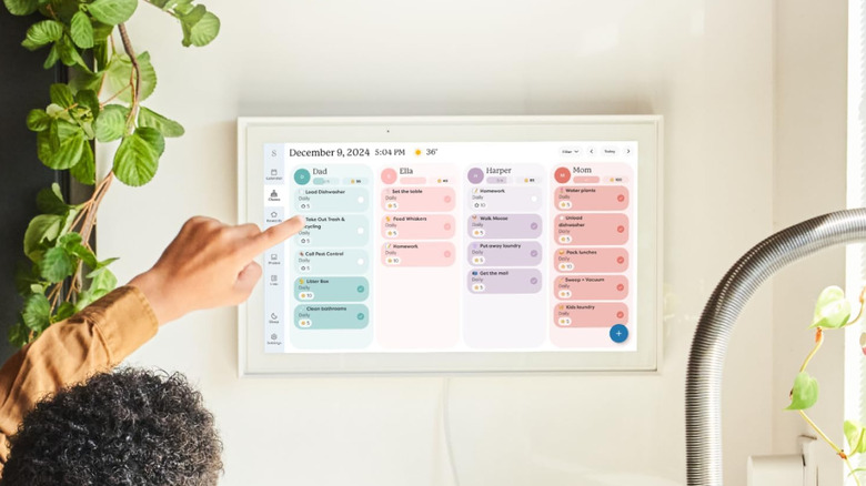Child pointing at smart touchscreen calendar during December