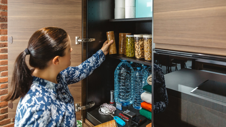 person organizing kitchen cabinets