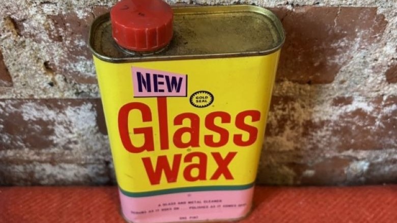 Can of Gold Seal Glass Wax against a cement wall
