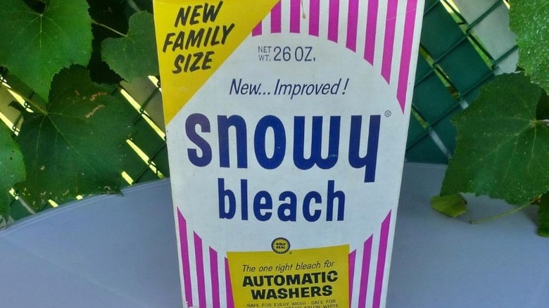 A pack of Snowy Bleach sitting on a table with greenery in the background