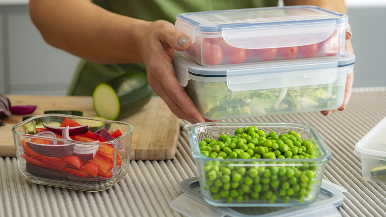 Person packing food in rectangular stacking food storage containers