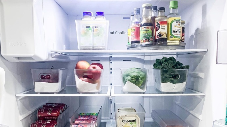 Well-organized fridge with a plastic lazy susan on the top shelf holding condiments