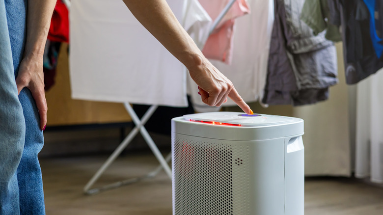 person turning on a dehumidifier in laundry room