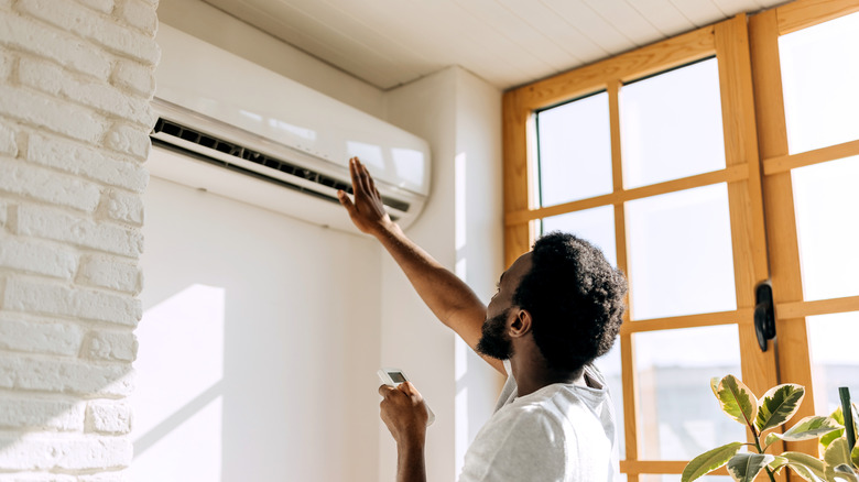 man checking the cooling effect of the air conditioner in his home