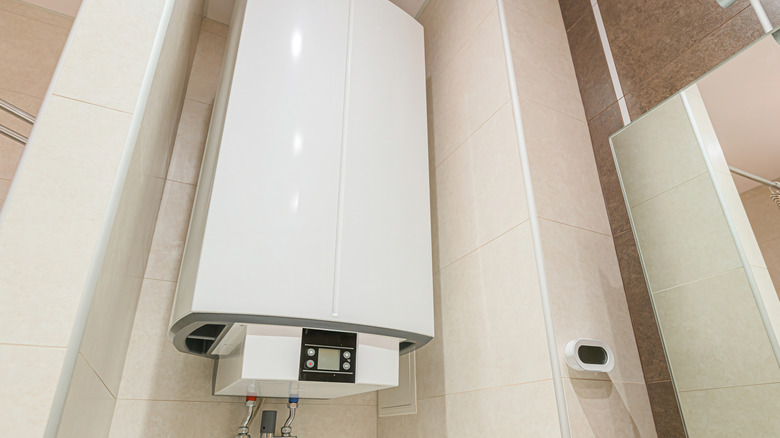 tanked water heater mounted on a bathroom wall