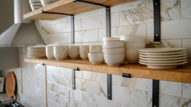 Close up of open kitchen shelves with cups and plates