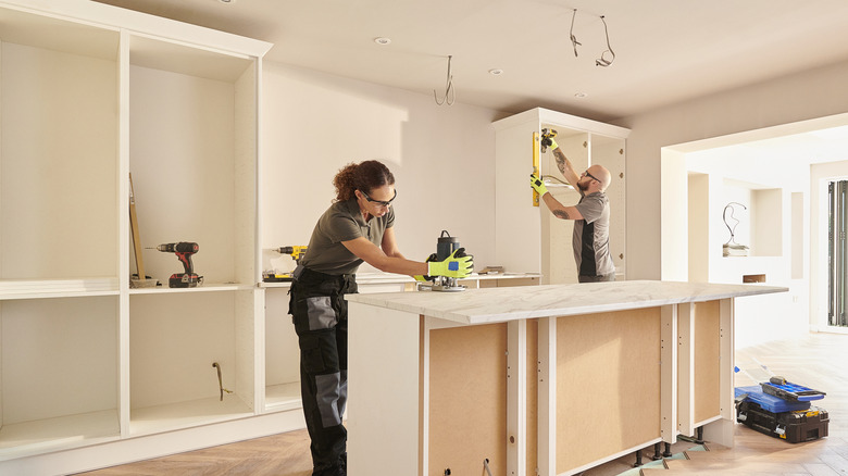 Kitchen fitters building storage in a kitchen with bright natural light