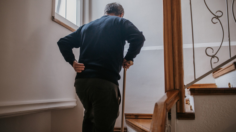 senior ma walking up stairs with hands on waist