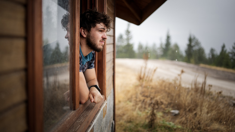 Person looking out a window in home without outdoor features