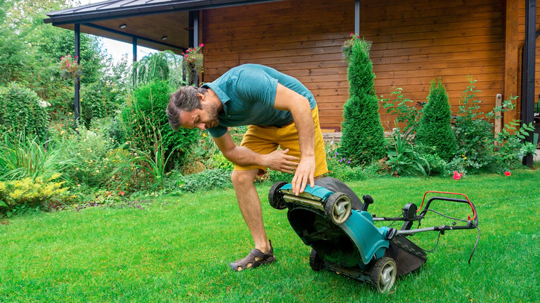 Man checking lawn mower