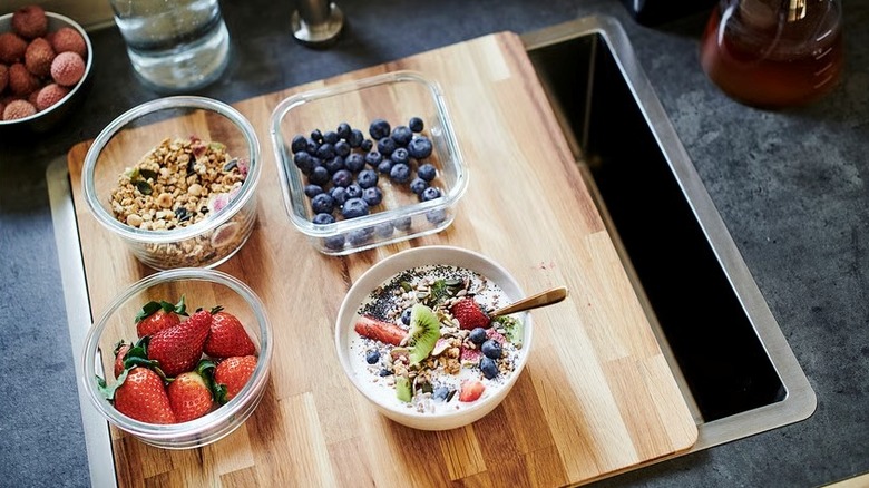 IKEA's NORRSJÖN cutting board over a sink with bowls of fruit
