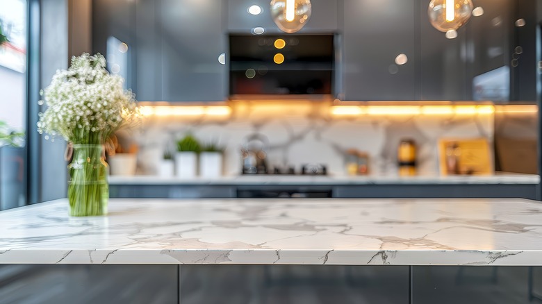 Zoomed in image of white marble countertop on kitchen island with dark cabinets