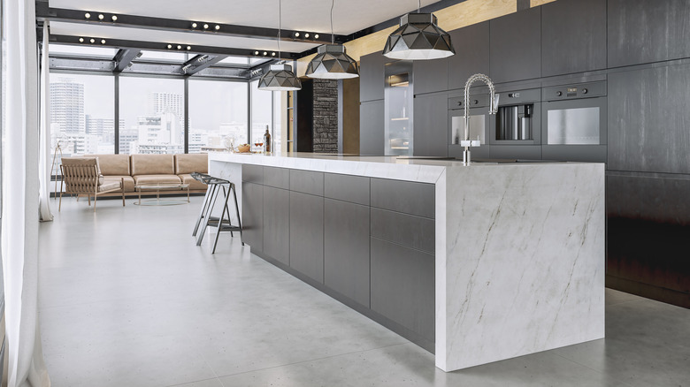 Beautiful kitchen with black cabinets and white waterfall countertop