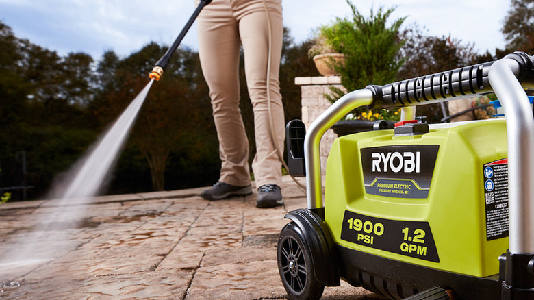 Person using the Ryobi Electric Pressure Washer to clean a patio