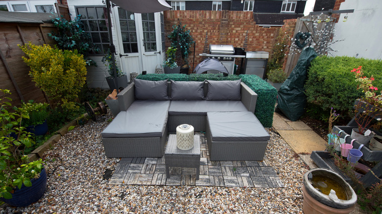 Seating sectional on gravel and wood patio