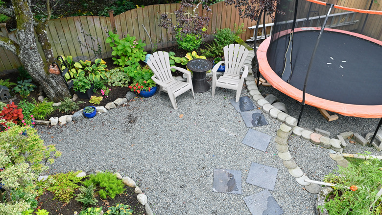 Gravel play patio with trampoline and chairs