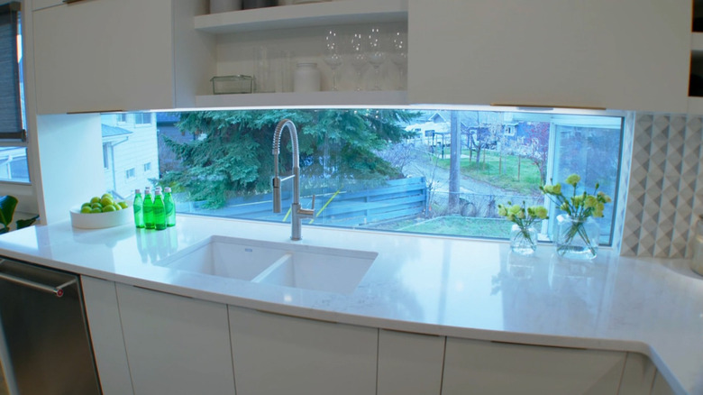 A window backsplash over a modern kitchen sink.