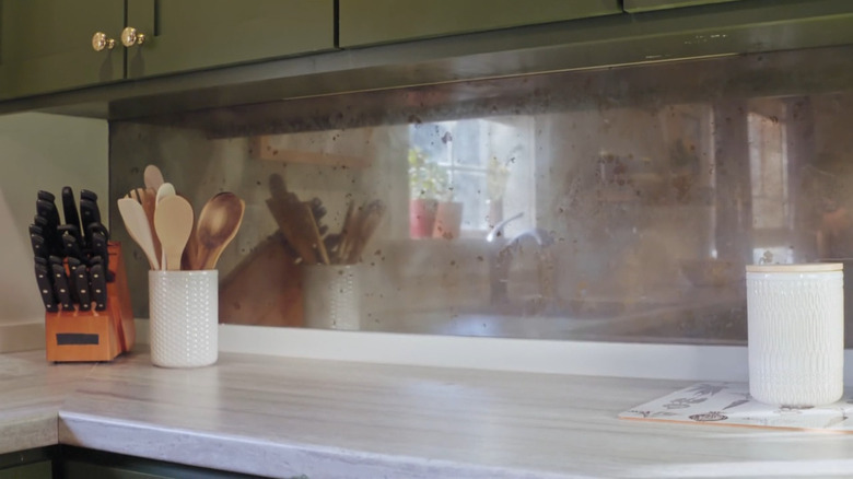 A close up of a vintage mirrored backsplash.
