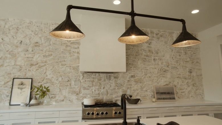 Leanne Ford places a pot in a white kitchen.