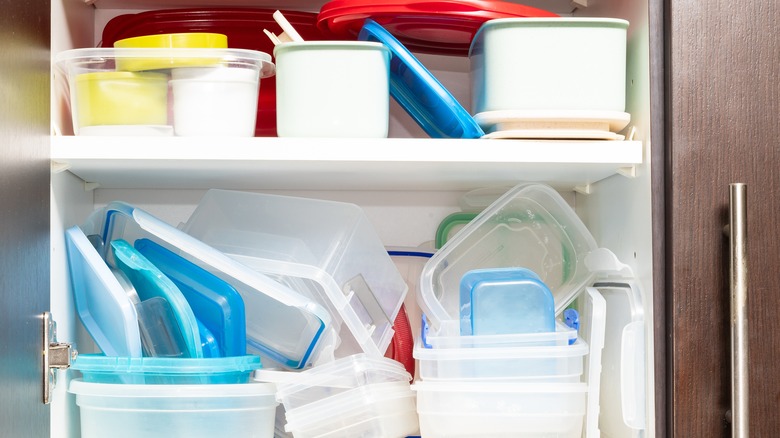 Cupboard filled with random plastic food containers