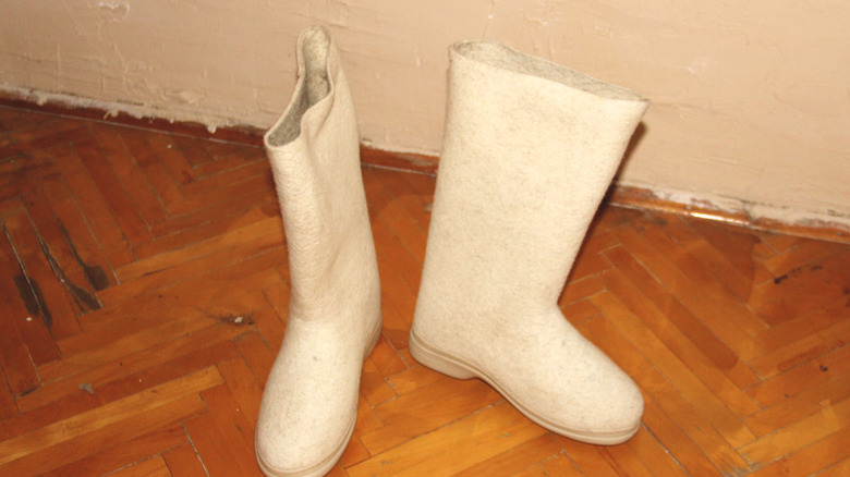 Thick white boots on a hardwood floor