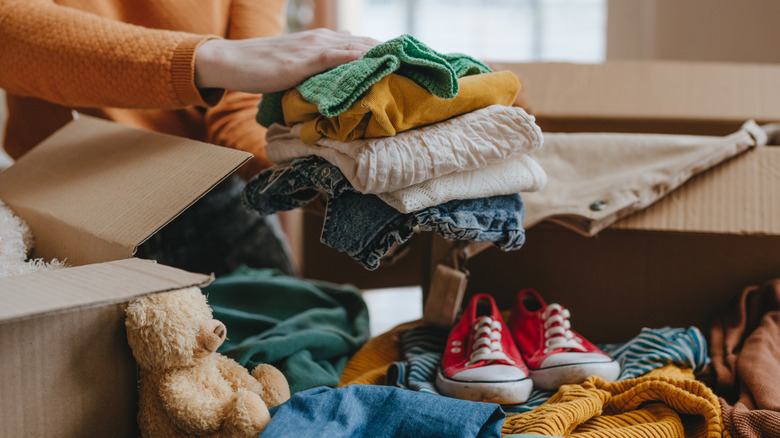 Woman packing old baby clothes in a box