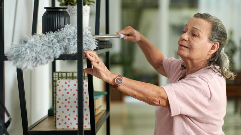 Woman using a duster on a shelf