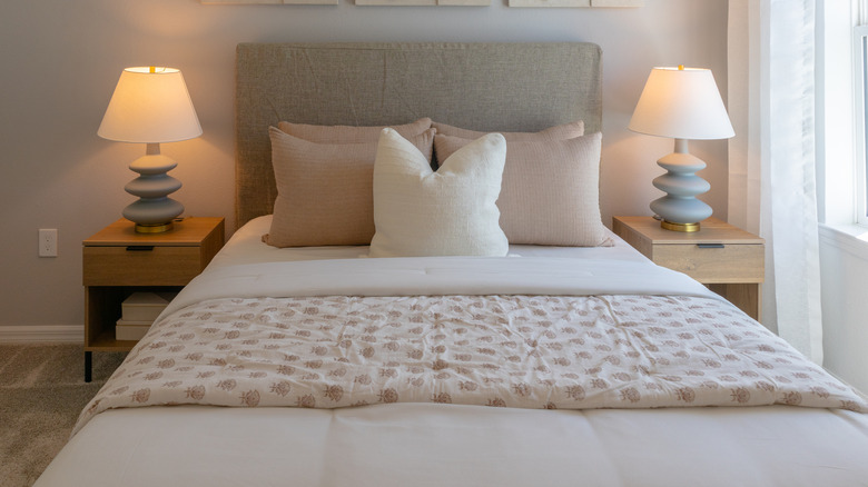 Guest bedroom with the bed made and lamps on either side