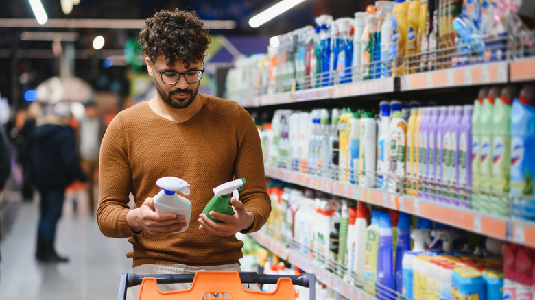 Man shopping for bottled cleaning products