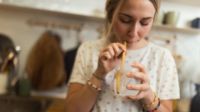 Woman drinking water through straw