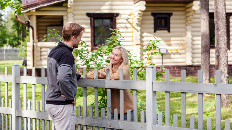 Neighbors talking over the garden fence