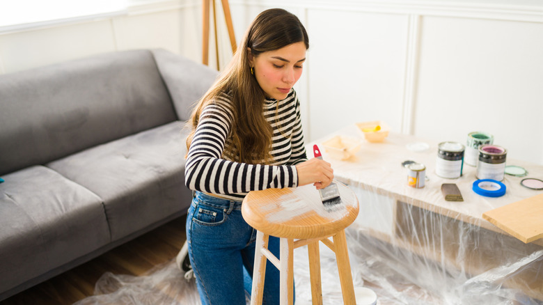 Woman painting a stool white