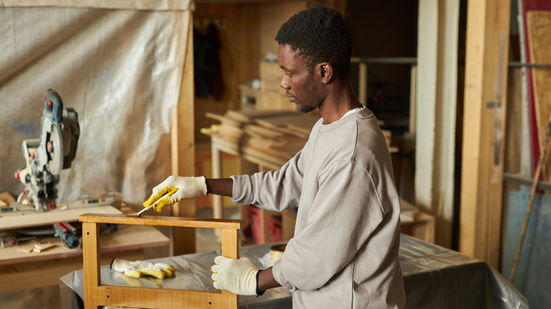 A man sealing a piece of wood furniture