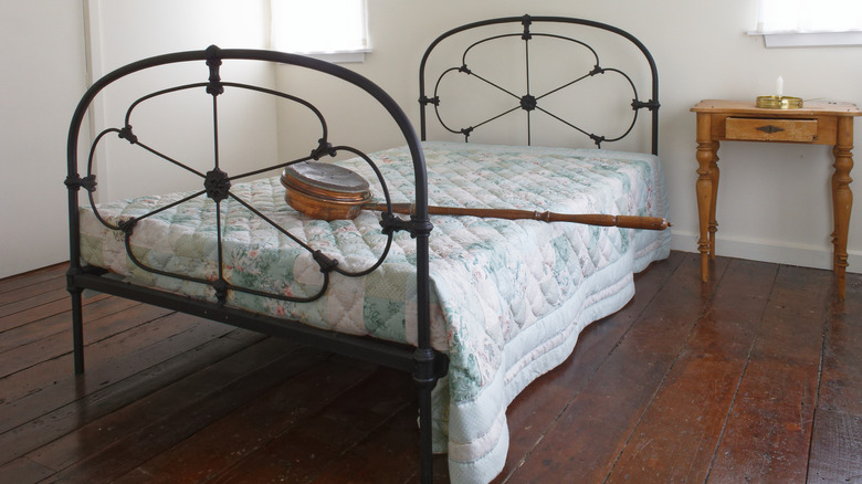 A simple room with an antique bed with a metal frame