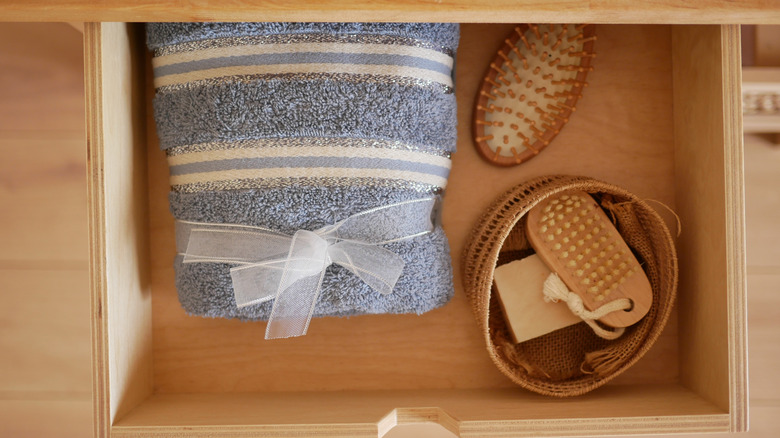 Bathroom drawer with towel, tray, and brushes