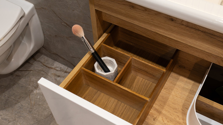 Deep bathroom drawer with containers and makeup brush