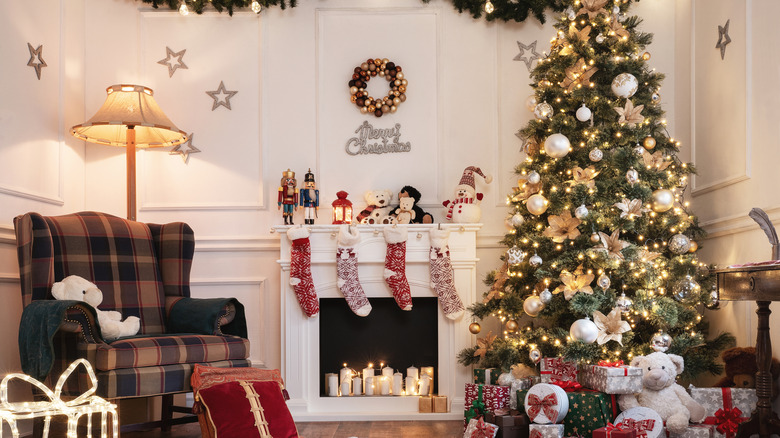 Living room with a fireplace and a chair decorated for Christmas with a tree, stockings, and wreath