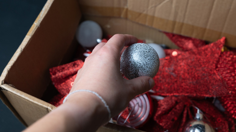 Person reaching into a box of random Christmas decorations