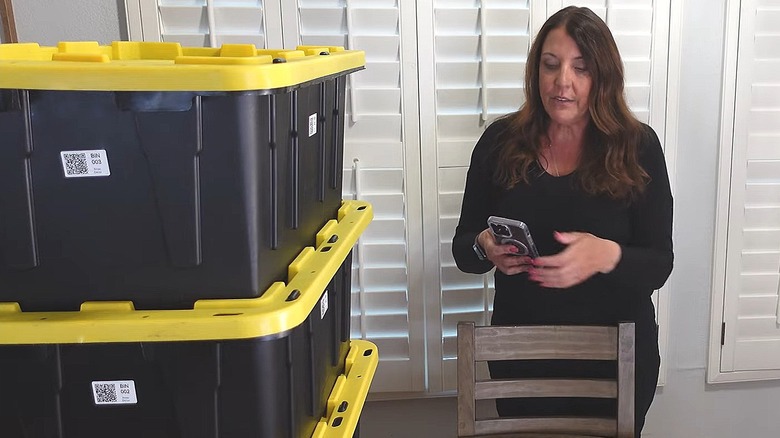 Storage bins with QR code labels on them and woman accessing label information