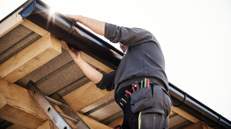 person adjusting gutter