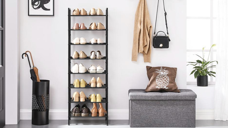 8-tier shoe rack in a living room with plants, umbrellas, and seating